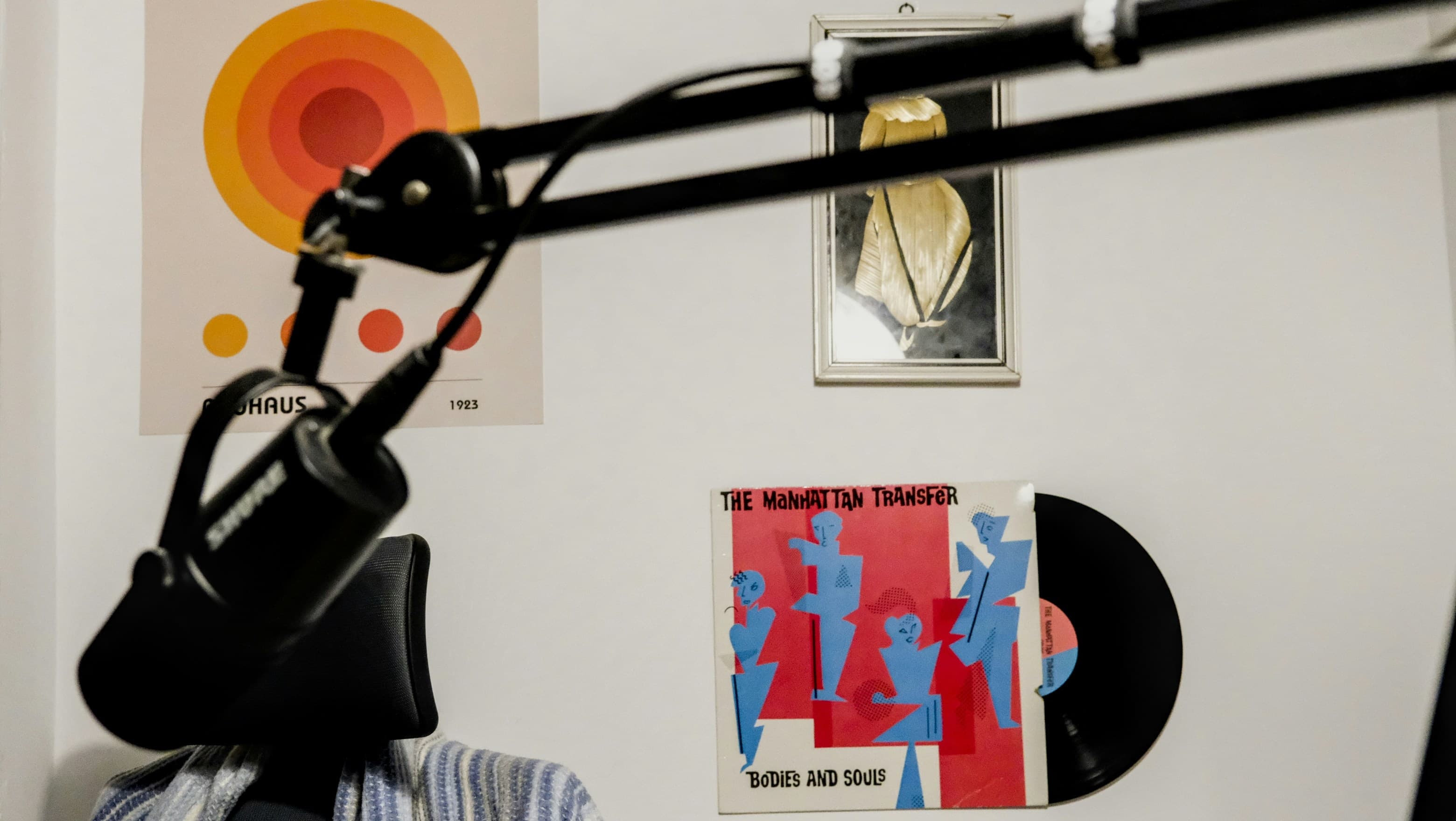 The Bauhaus print and a record sleeve on a white wall, seen past a microphone boom